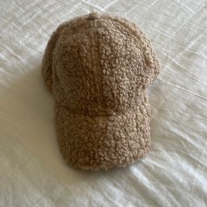 Sherpa tan/cream hat with Velcro adjustable strap on back.